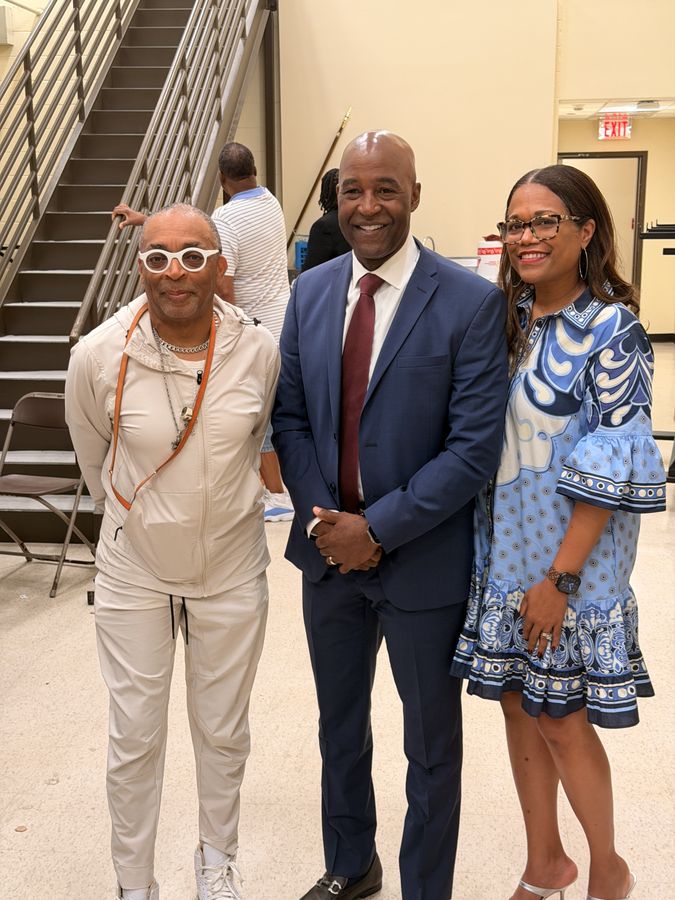 Three guests smiling together at a community event