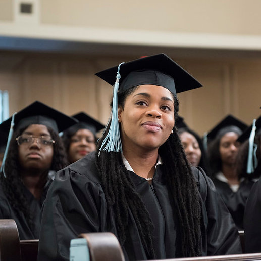 A Spelman graduate in cap and gown at commencement